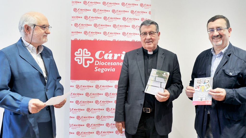 Mariano Illana, Ángel Galindo y José Magaña, muestran la memoria de actividades de Caritas en la presentación. / KAMARERO