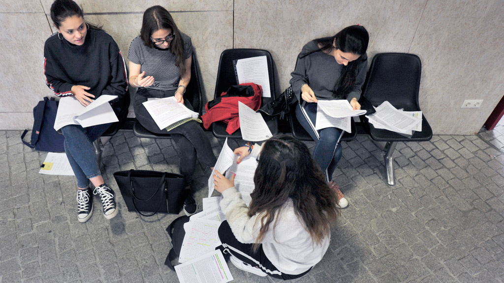 Un grupo de estudiantes repasan sus apuntes, ‘cantan’ temas y comparten sus dudas para templar nervios antes de entrar a hacer el ejercicio de Historia de España. / KAMARERO