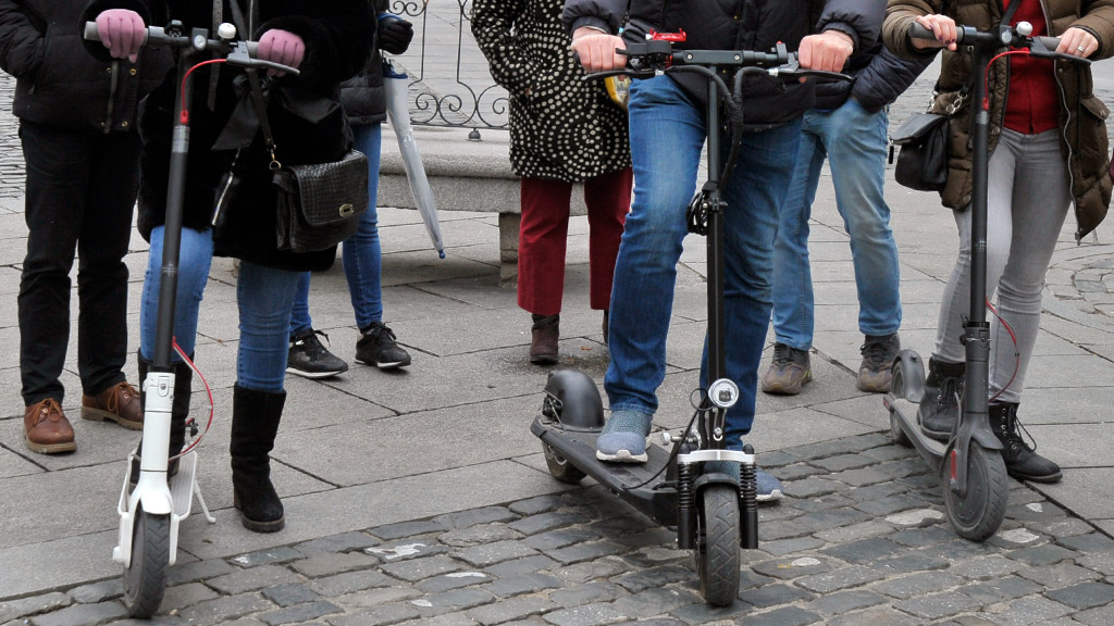 Varias personas montan en patinete eléctrico. / Kamarero