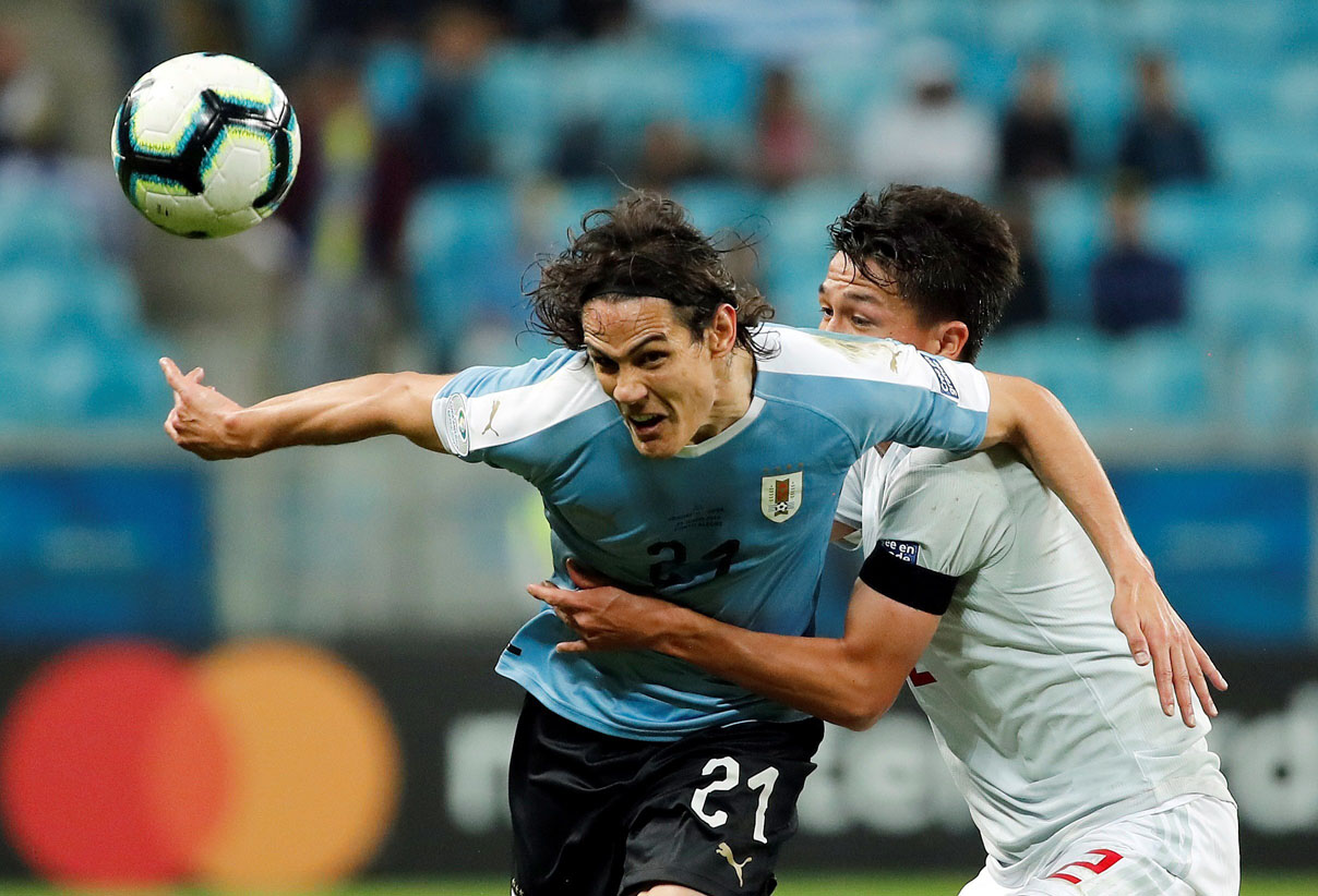 El uruguayo Cavani disputa un balón con el japonés Daiki Sugioka. / EFE