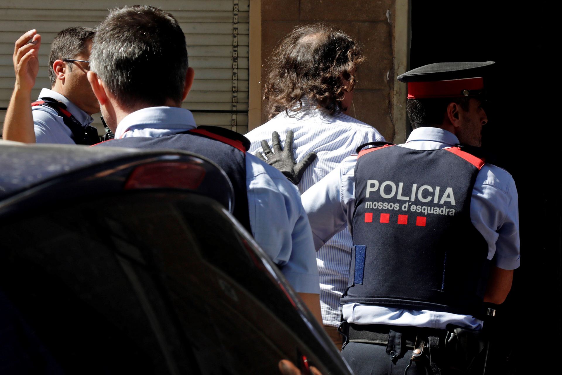 Agentes de los Mossos trasladan al autor confeso del crimen a la vivienda de los hechos para presenciar el registro. / EFE