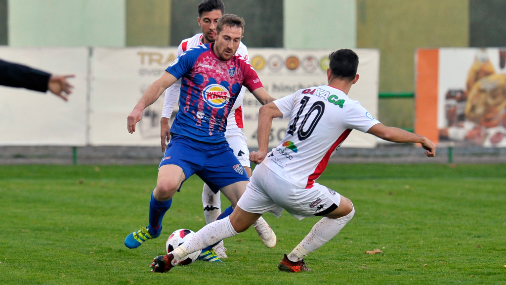 El atacante de la Gimnástica Segoviana Dani Arribas trata de marcharse de un contrincante del Zamora. / KAMARERO