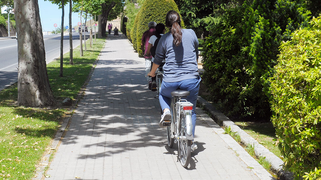 Una mujer circula en bicicleta por la ciudad. / Kamarero