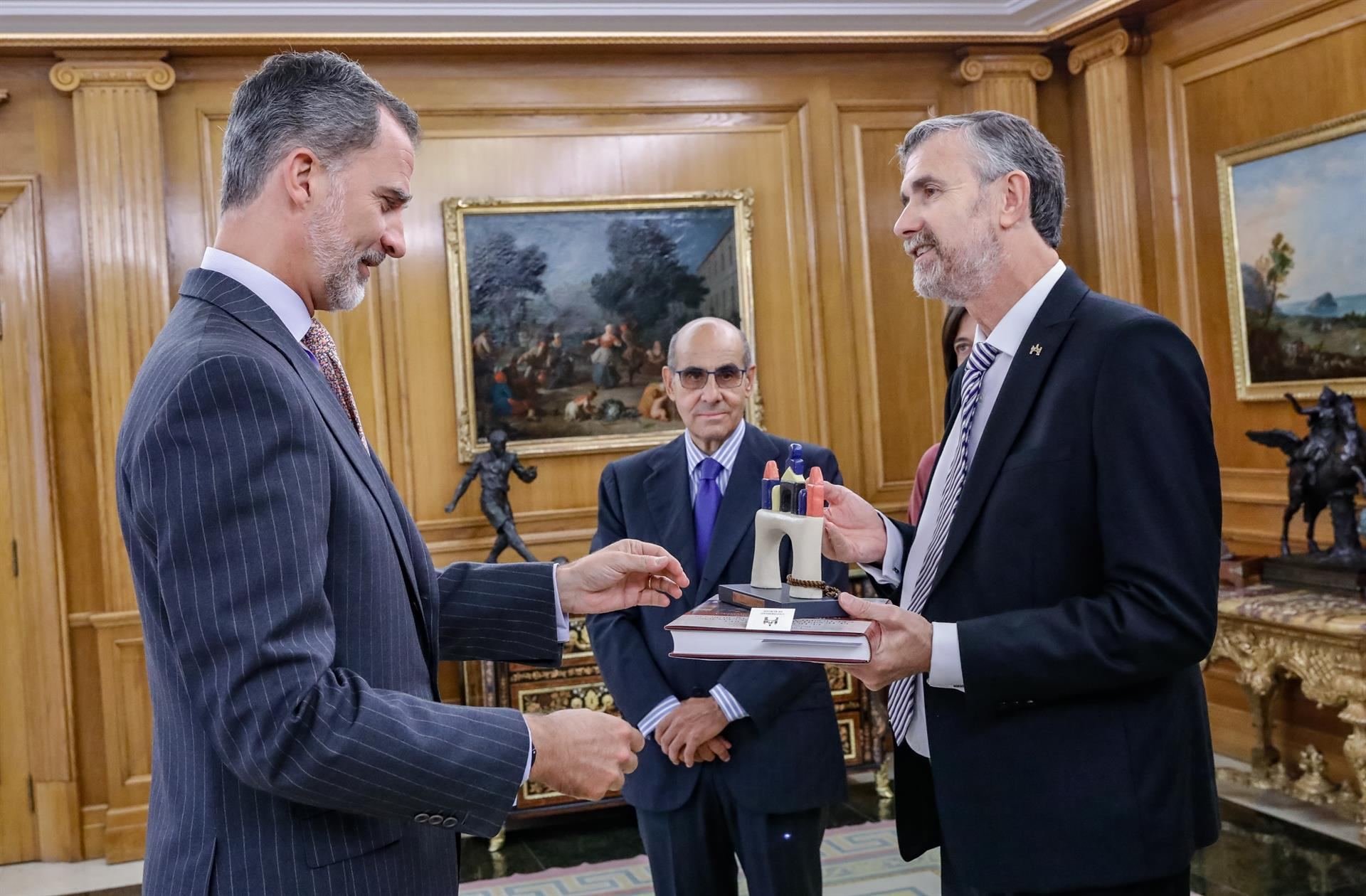 Manuel Pérez Mateos, rector de la UBU, entrega a Felipe VI un regalo por su visita. / Europa press