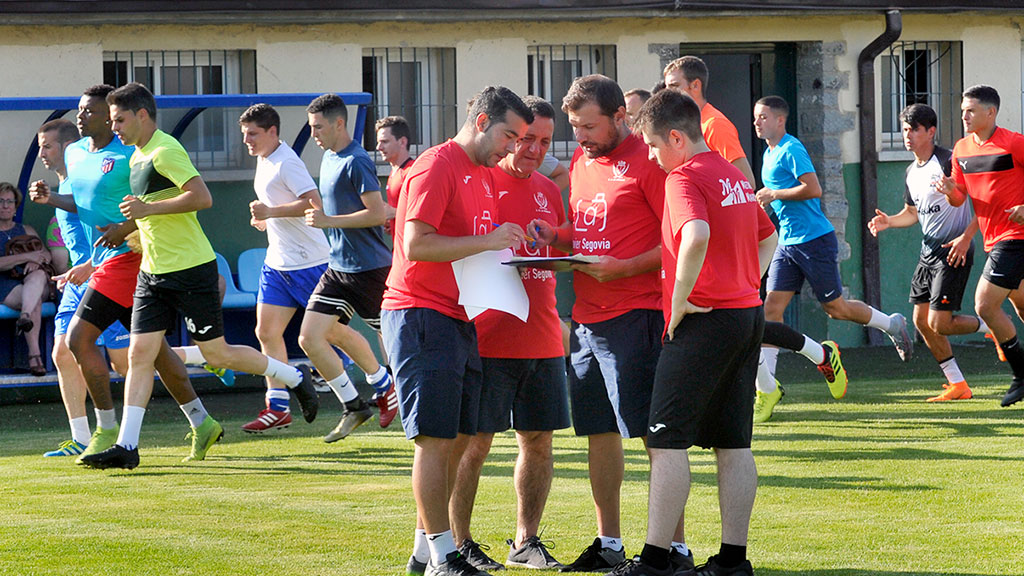 El cuerpo técnico del CD La Granja dialoga mientras los jugadores hacen carrera continua. / KAMARERO