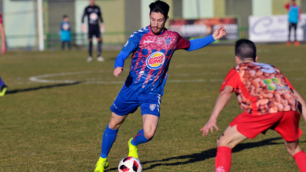 El jugador de la Segoviana, Adrián, golpea la pelota durante el partido de la pasada liga ante el CD La Granja en La Albuera. / KAMARERO