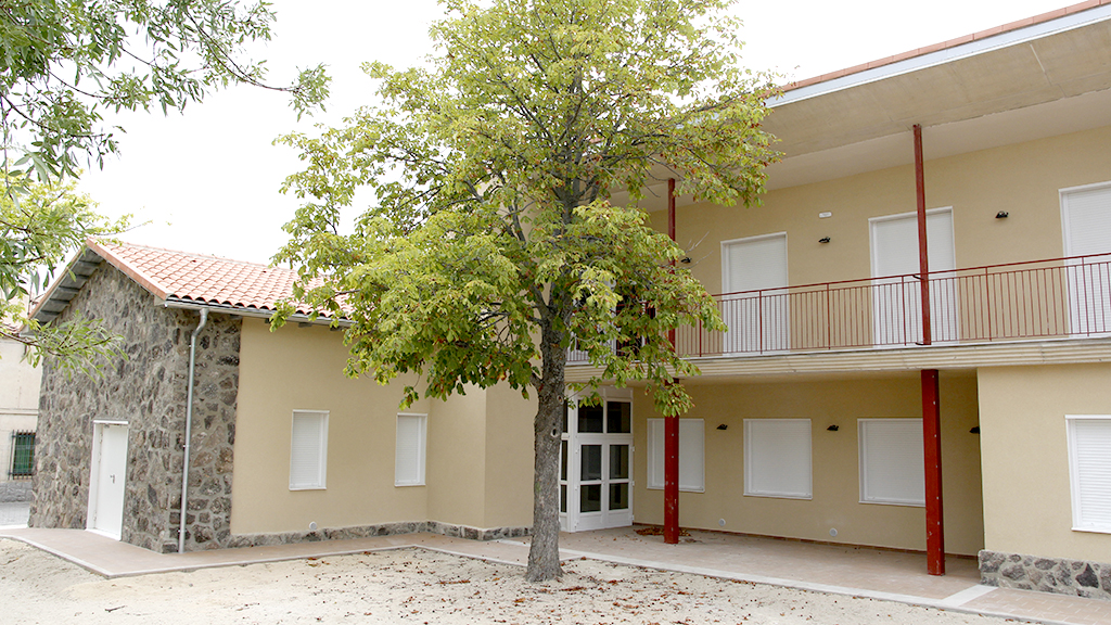 El edificio tiene forma de L y está abierto hacia una zona ajardinada, cerca de la travesía y la iglesia parroquial. /  NEREA LLORENTE