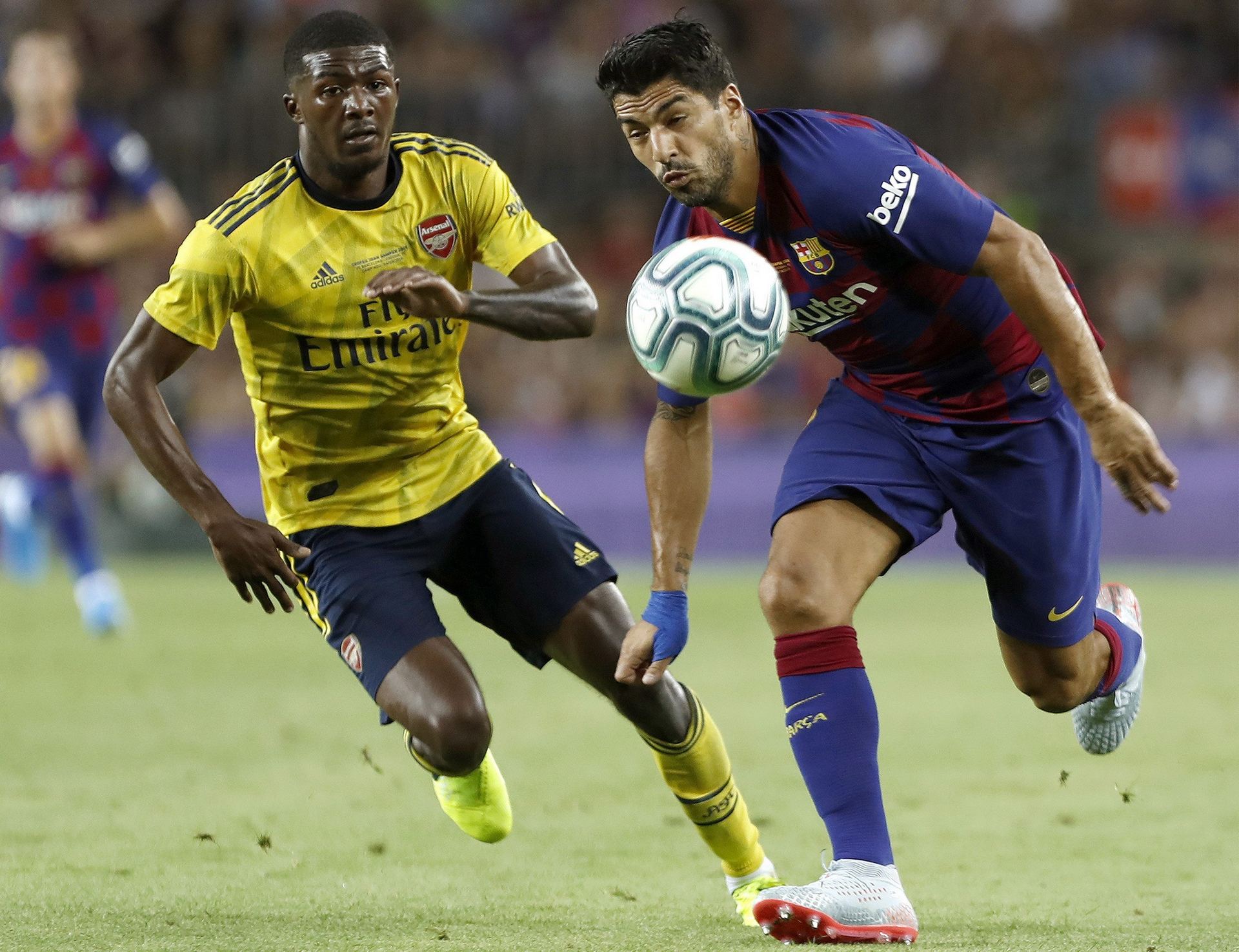 El delantero del FC Barcelona Luis Suárez pelea un balón con Ainsley Maitland-Niles, del Arsenal. / efe