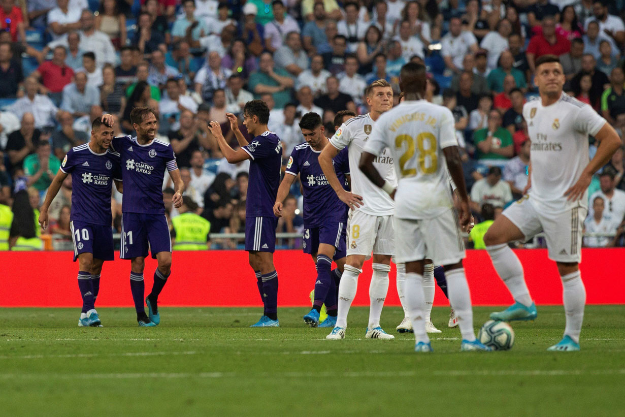 Los jugadores del Real Madrid (dcha) se lamentan mientras celebran los del Valladolid el gol del empate en el Santiago Bernabéu. / EFE