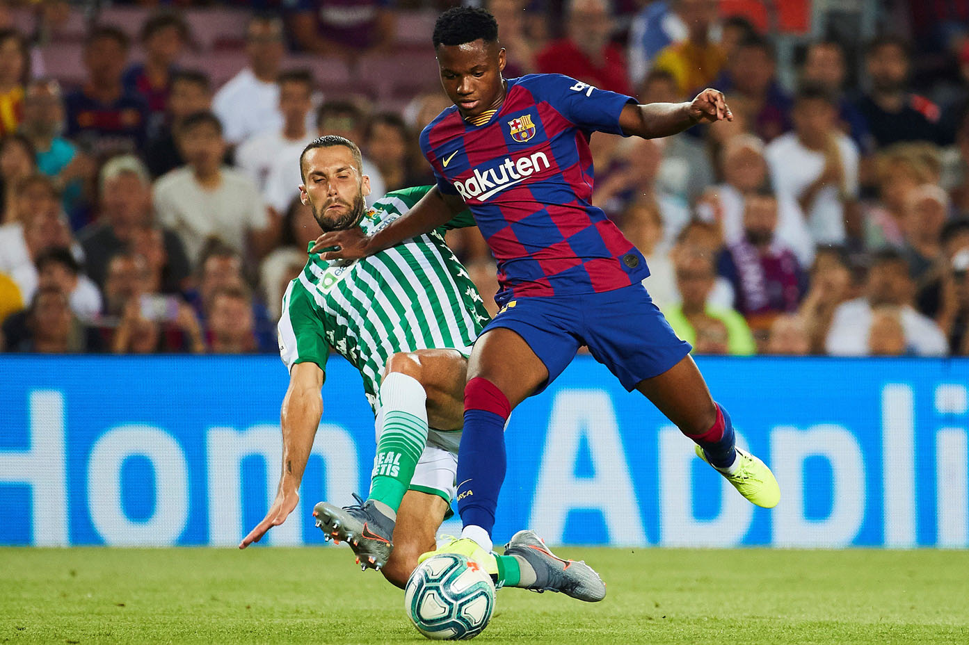 Ansu Fati intenta llevarse el balón ante la entrada del defensa del Betis Alfonso Pedraza el domingo en el Camp Nou. / EFE