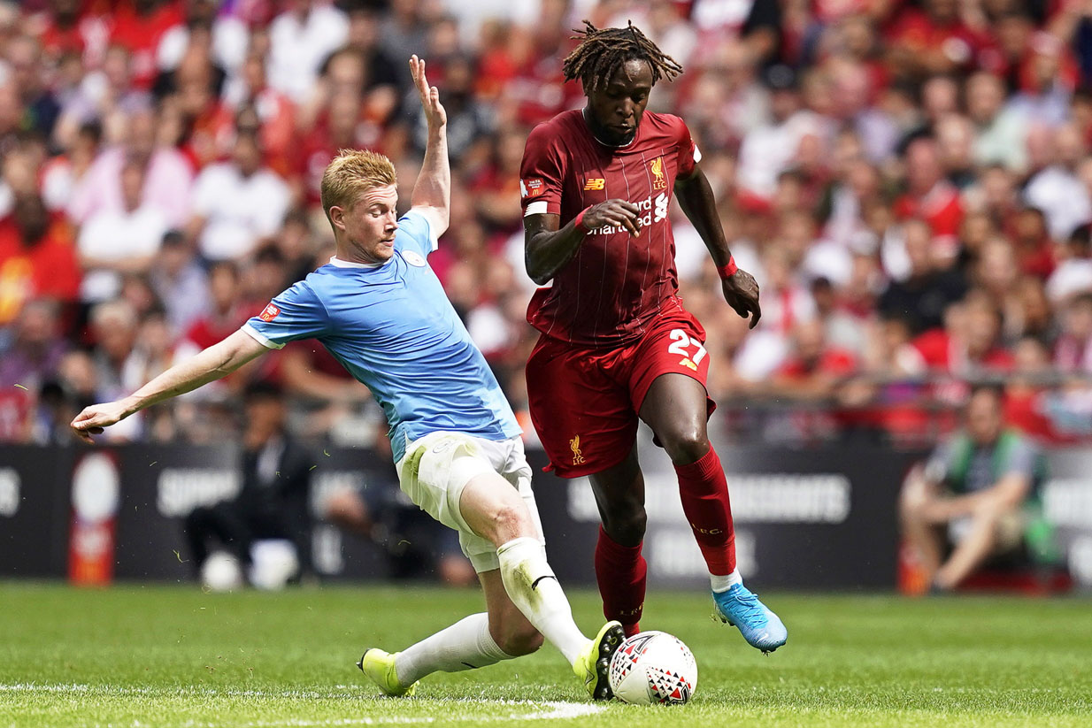 De Bruyne (izq), del Manchester City, corta el avance de Origi, del Liverpool. / EFE