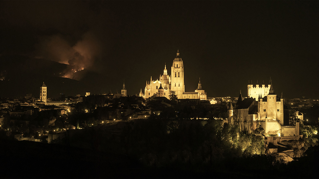 Bella y terrible imagen nocturna de dos de los principales monumentos de Segovia la pasada noche, con el incendio de La Granja de fondo. / Basilio Rubio