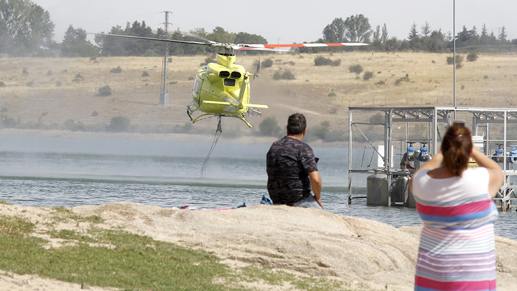 Numerosas familias se acercaron ayer al embalse para ver cargar agua a los medios aéreos de extinción. / Nerea Llorente