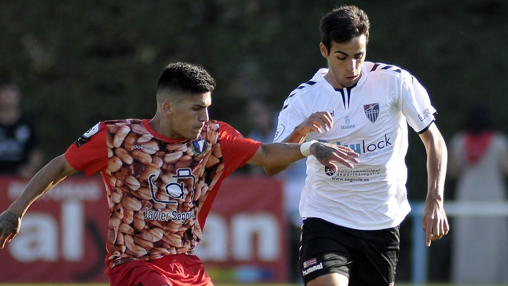 Tomás, del CD La Granja, trata de frenar la proyección de Diego Gómez, de la Segoviana. / JUAN MARTÍN