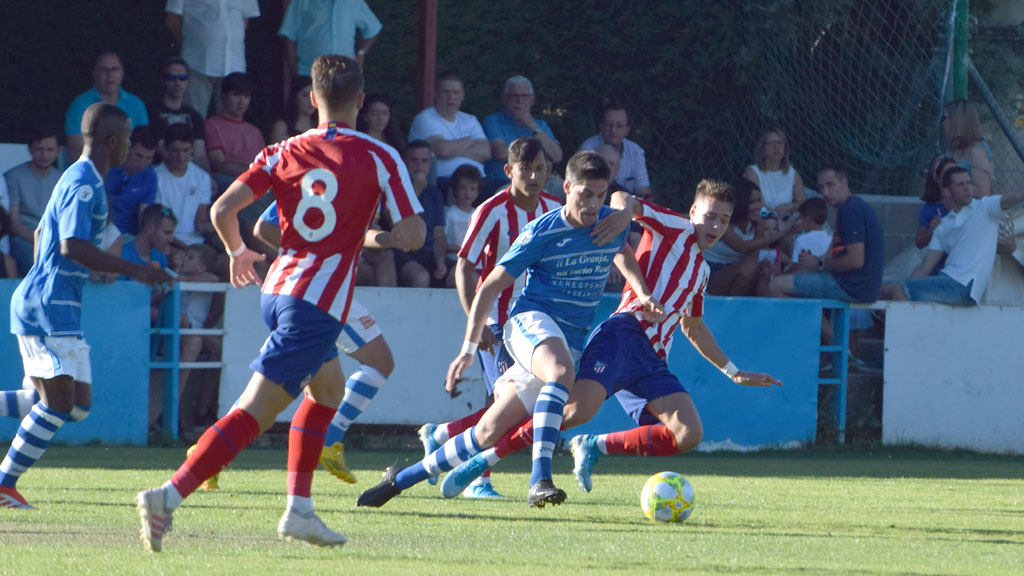 El central del CD La Granja Enrique Llorente ‘Kike’ intenta salir de la presión de los jugadores del Atlético. / ROCÍO PARDOS