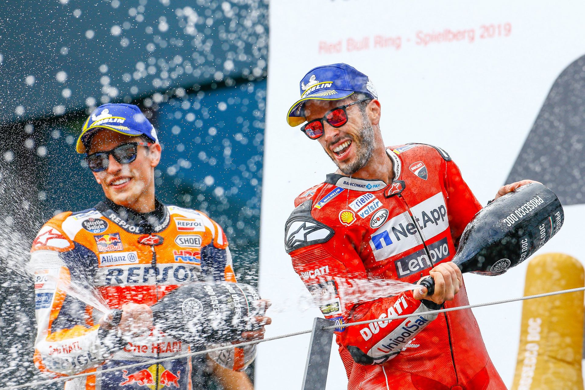El piloto de Honda Marc Márquez (i) y el de Ducati Andrea Dovizioso celebran su segundo y primer puesto en el Red Bull Ring in Spielberg. / EFE