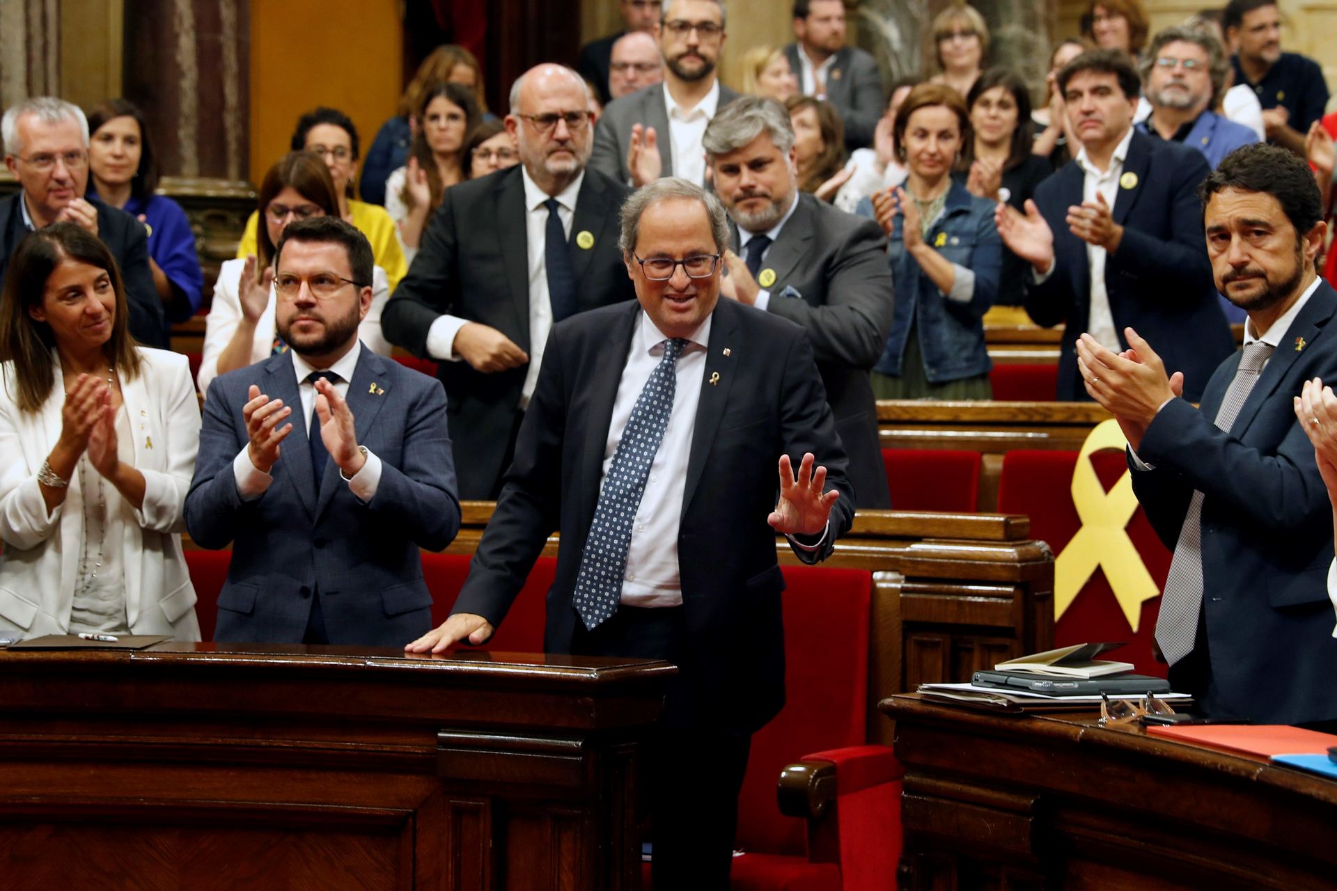 El presidente catalán recibe los aplausos de los diputados de JxCat y ERC tras su discurso en el parlamento.