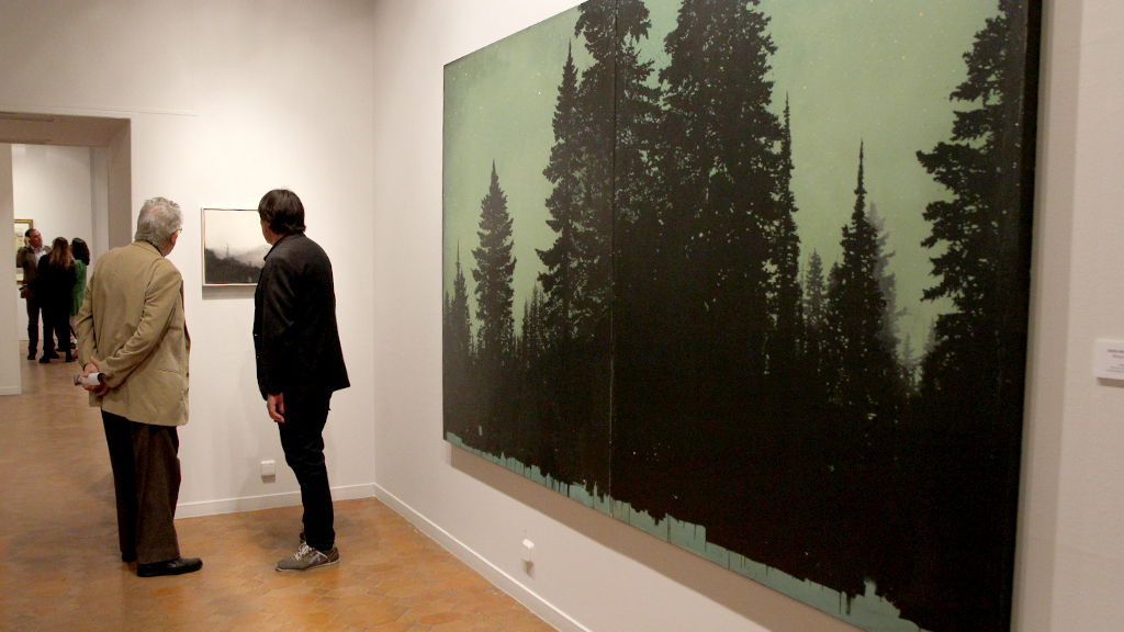 Dos personas contemplan una de las obras de la colección, que desde ayer se pueden ver en las salas del Palacio y de las Caballerizas. / nerea llorente