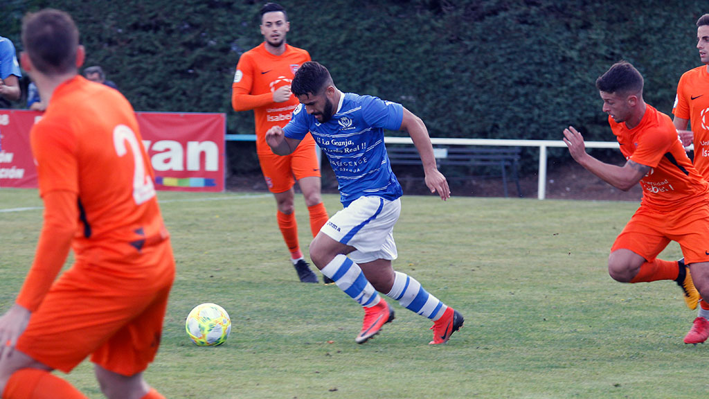 El centrocampista del CD La Granja Vitolo conduce el esférico ante la presión de varios rivales. / NEREA LLORENTE
