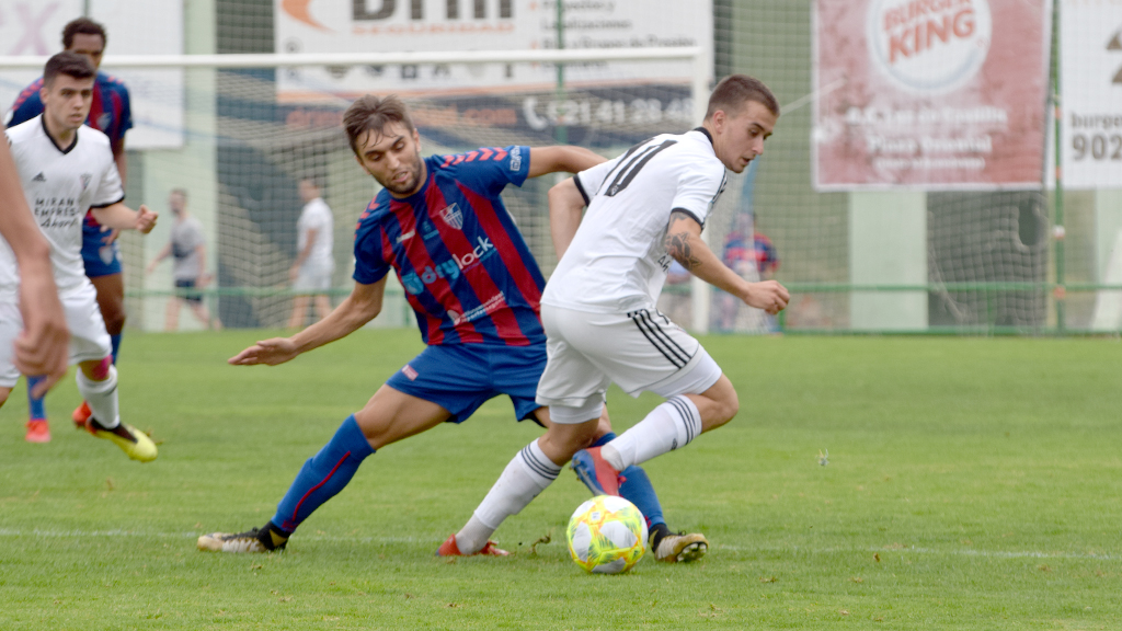 El mediapunta de la Segoviana Álex Conde intenta robar un balón a un jugador del Mirandés B. / ROCÍO PARDOS