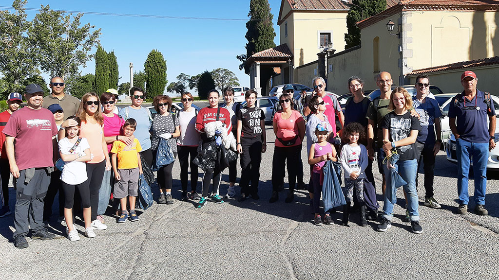Los voluntarios de la jornada de limpieza posan frente al cementerio tras una mañana de trabajo. / El Adelantado