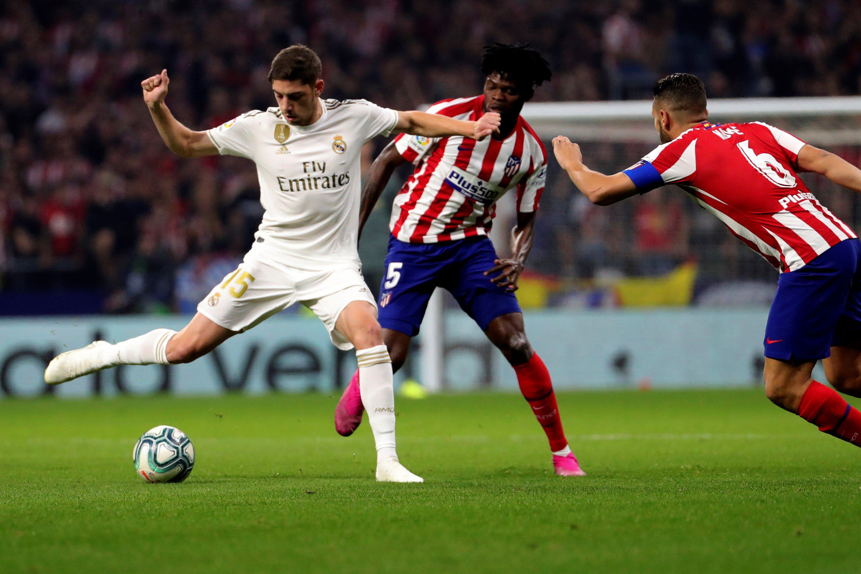 Fede Valverde, titular en el Wanda Metropolitano ante el Atlético y en el Bernabéu contra el Granada, protege el balón ante la presión de Thomas y Koke. / EFE