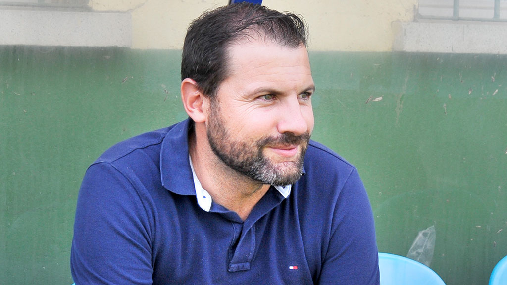 El entrenador del CD La Granja, Carlos Fonseca, en el banquillo, durante un partido en el campo de El Hospital. / KAMARERO