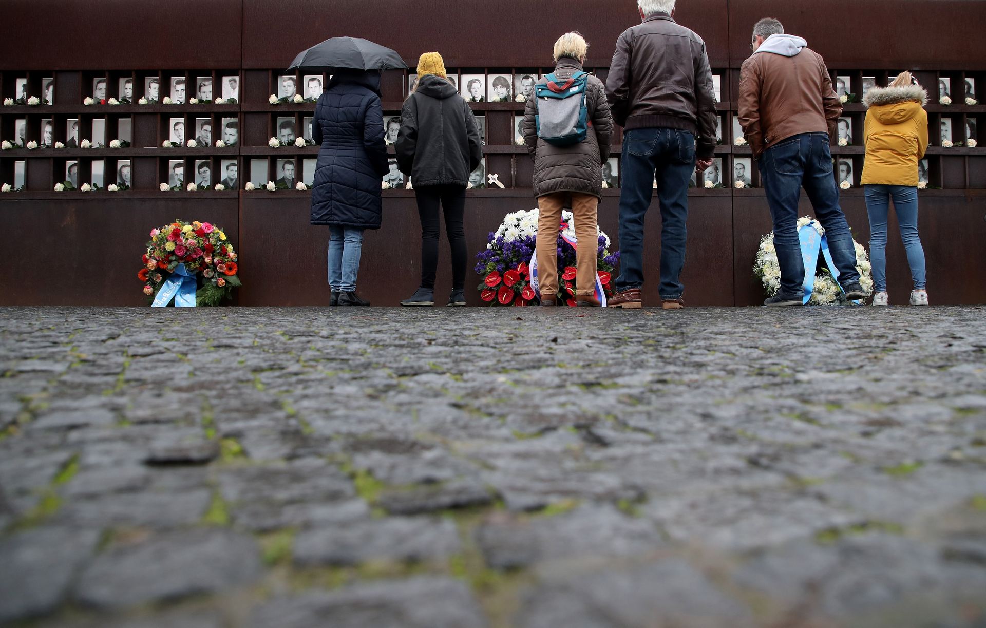 Visitantes en el Memorial del Muro de Berlín ante los retratos de los que fallecieron al intentar cruzar el Telón de Acero.
