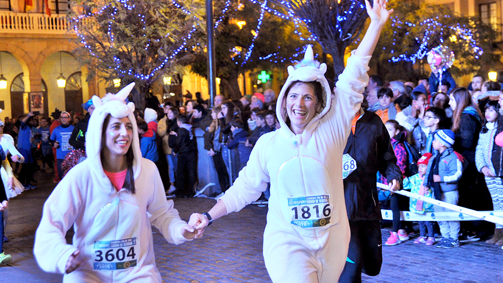 Dos corredores de la Carrera Fin de Año, a su paso por la Plaza Mayor. / A. MARUGÁN