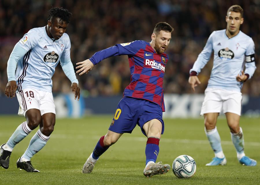 Leo Messi intenta superar la presión de Aidoo (izq) en el partido entre el Barcelona y el Celta, disputado el pasado sábado en el Camp Nou. / EFE