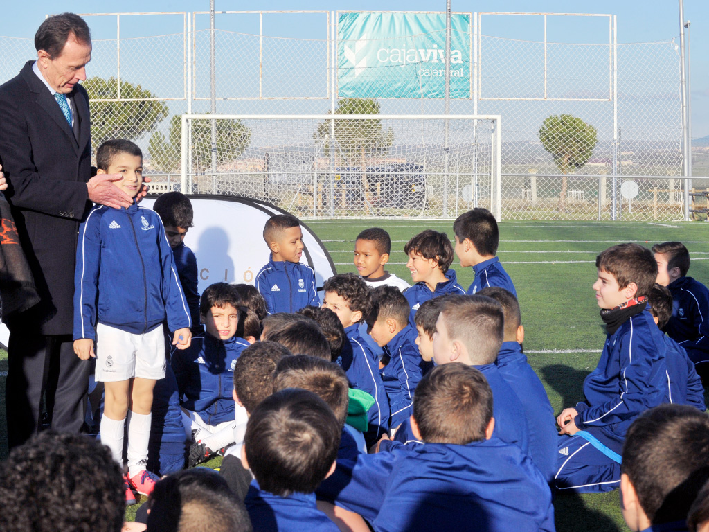 Emilio Butragueño, con varios de los jóvenes integrantes de la Escuela socio-deportiva de fútbol. / KAMARERO