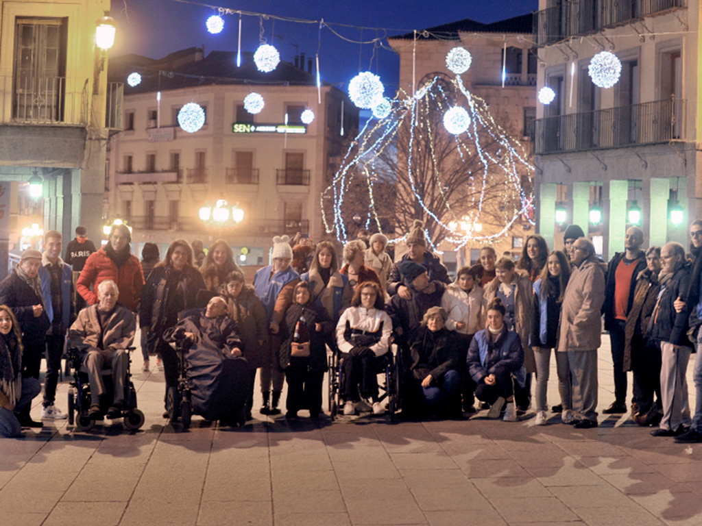 n n n Voluntarios de Cooperación Internacional, estudiantes de la Universidad de Valladolid en su gran mayoría, han acompañado a los residentes del Centro de Atención a Minusválidos Psíquicos de ‘El Sotillo’ a descubrir el alumbrado navideño en la capital segoviana, cantando villancicos y con una pausa para tomar alguna bebida. 
La actividad, en la que participaron en torno a 25 residentes del citado CAMP, dependiente de la Diputación, se ha enmarcado dentro de la actividad de voluntariado que se desarrolla durante el curso desde 2018. / Kamarero