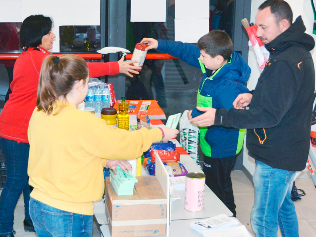 Aficionados haciendo entrega de sus donaciones de comida en los prolegómenos del partido. / AMADOR MARUGÁN