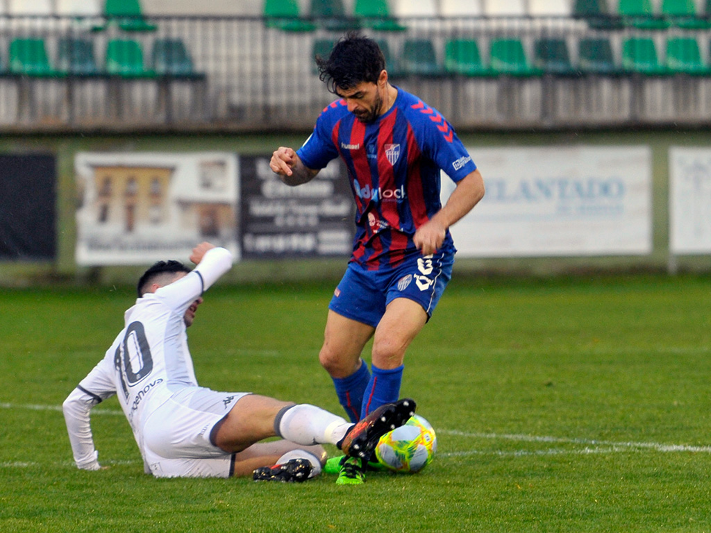 El centrocampista de la Gimnástica Segoviana Domingo Pérez se marcha de un rival del Júpiter Leonés. / KAMARERO
