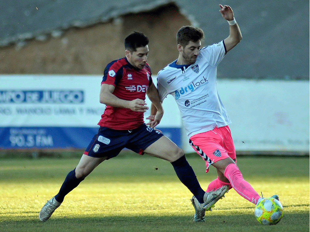 El jugador de la Gimnástica Segoviana Dani Calleja intenta marchase de un contrincante del Real Ávila. / JUAN MARTÍN - LA GIMNÁSTICA