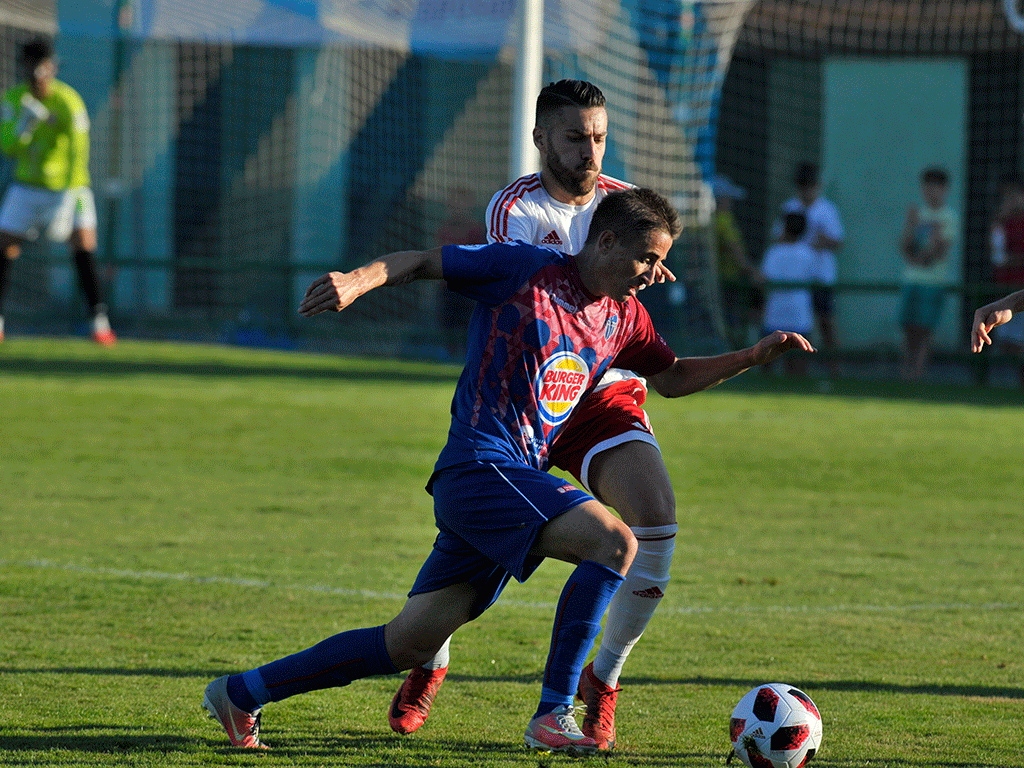 El jugador la Gimnástica Segoviana Asier Arranz trata de irse de un contrincante del Real Ávila.  / KAMARERO