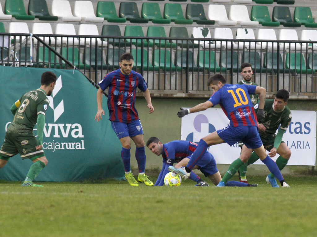 El jugador de la Gimnástica Segoviana Dani Calleja, autor de los dos goles del partido, controla un balón con la ayuda de Manu y Álex Conde. / NEREA LLORENTE