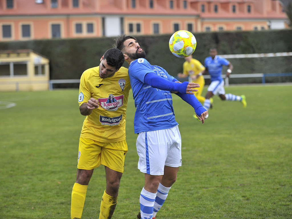 El jugador del CD La Granja, Vitolo, trata de controlar un balón ante la oposición de un defensa. / KAMARERO