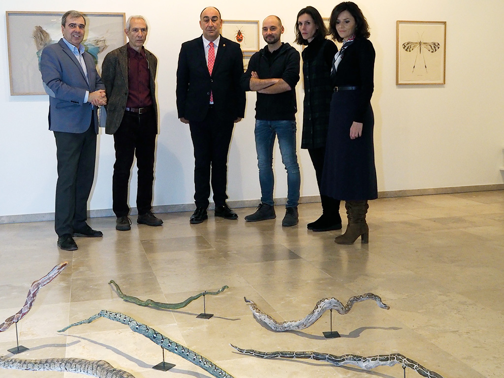 Ramas transformadas en serpientes, a los pies del artista y los responsables de ‘Semillero de arte’. / KAMARERO