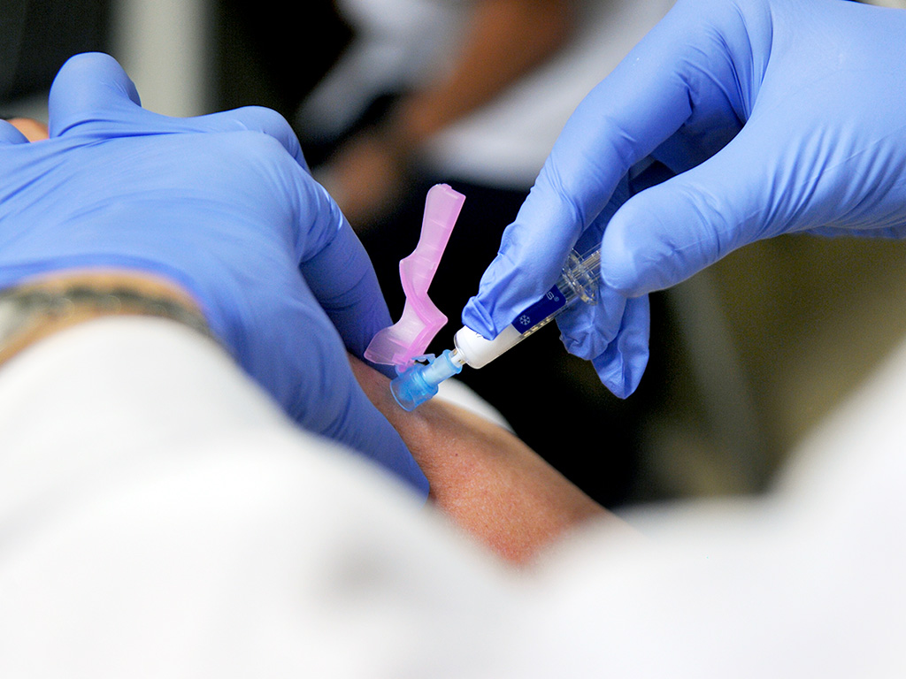 Personal sanitario administra una dosis de la vacuna contra la gripe. / KAMARERO