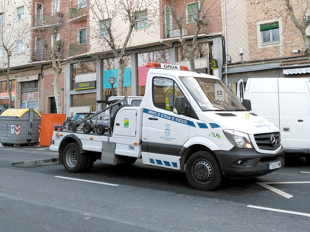 Una grúa del servicio municipal permanece estacionada junto varios vehículos. / Nerea Llorente