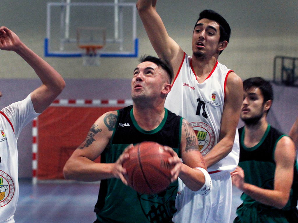 El jugador del CD Claret Borja Sanz intenta entrar a canasta ante la presión de los rivales del CB La Flecha. / NEREA LLORENTE