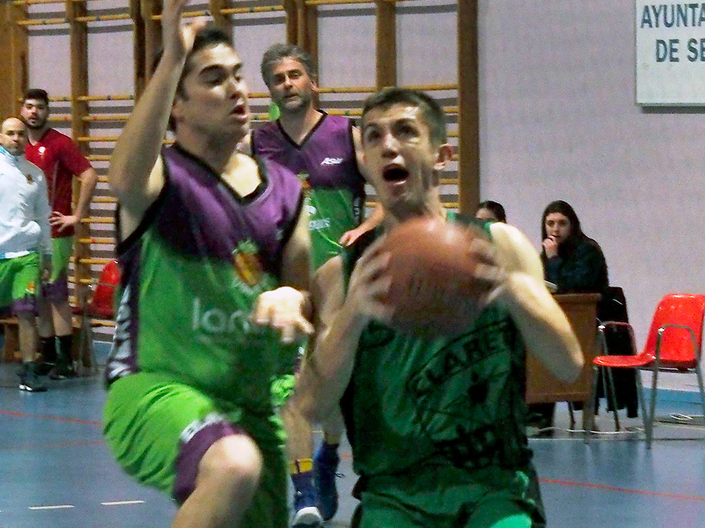 Javi Lázaro intenta la entrada a canasta con un jugador del Saltamontes Valverde intentando evitar que anote. / KAMARERO