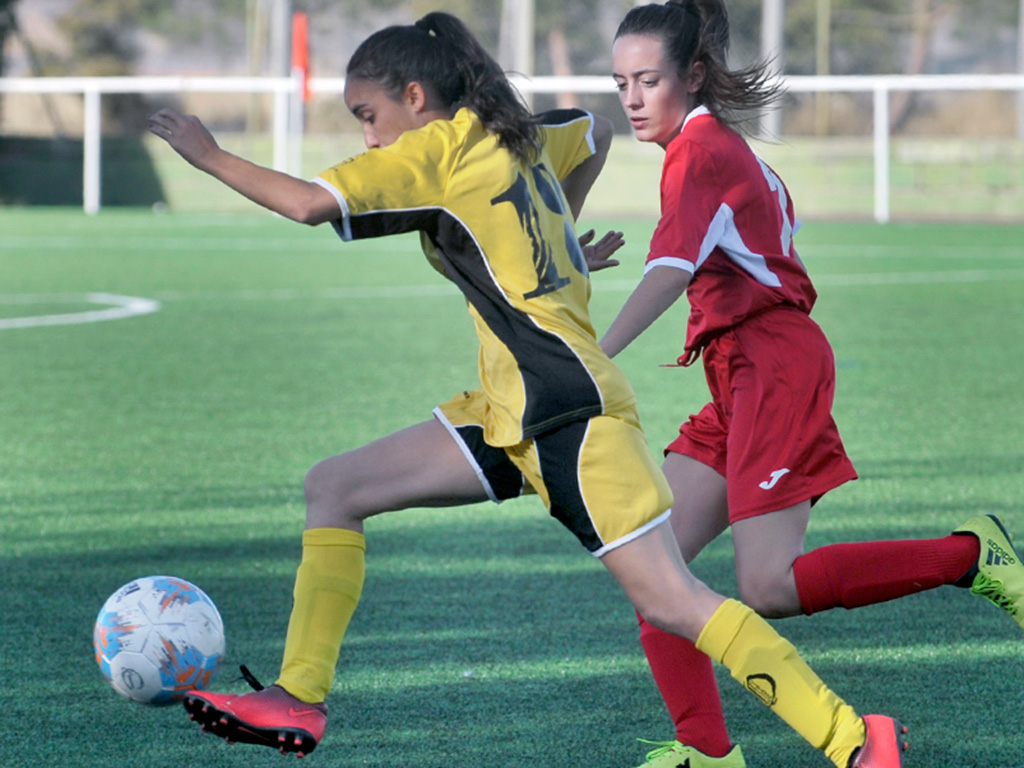 Una jugadora del CD Quintanar se va en velocidad de una rival. / KAMARERO