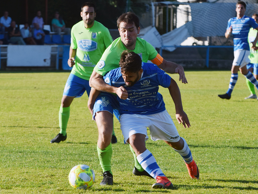 El jugador del CD La Granja Vitolo intenta salir con un balón ante la presión del capitán del Almazán. / ROCÍO PARDOS