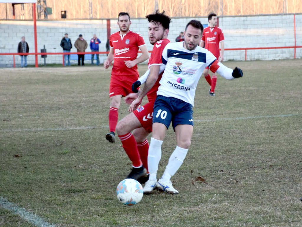 El delantero del Turégano Choflas agarra al capitán del Atlético Candeleda. / A.M.
