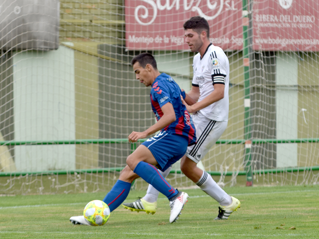 El delantero de la Segoviana Diego Gómez protege un balón ante la presión del capitán del Mirandés B. / ROCÍO PARDOS