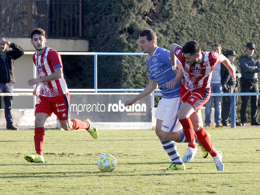 El centrocampista del CD La Granja Gabriel García ‘Gabi’ intenta irse de un rival del Bembibre. / NEREA LLORENTE