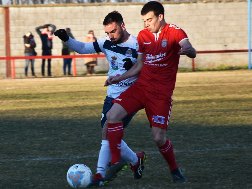 El centrocampista del Turégano Carlos conduce un balón ante la presión de un rival del Atlético Candeleda. / A.M.