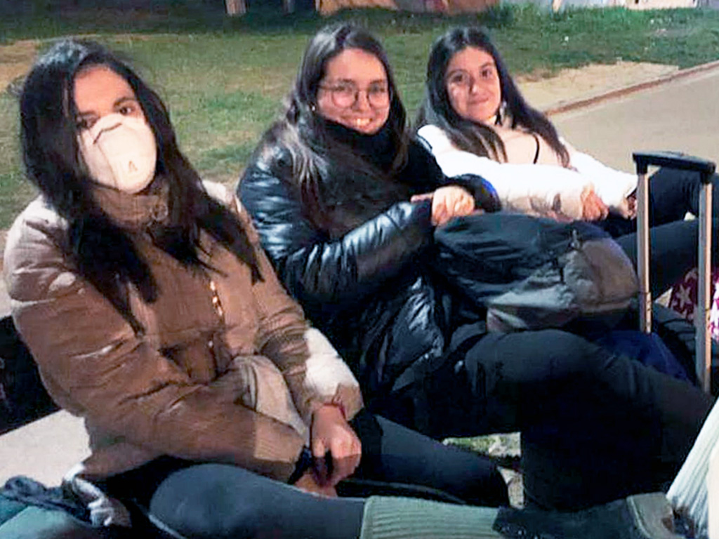 La joven segoviana con mascarilla esperando el autobús en su viaje de regreso desde Italia. /E. A.